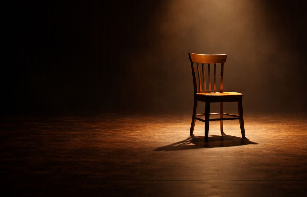 Escena de teatro contemporáneo con silla bajo foco — dramaturgia en español